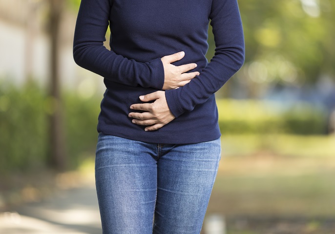 Frau hlt die Hnde vor ihren schmerzenden Bauch